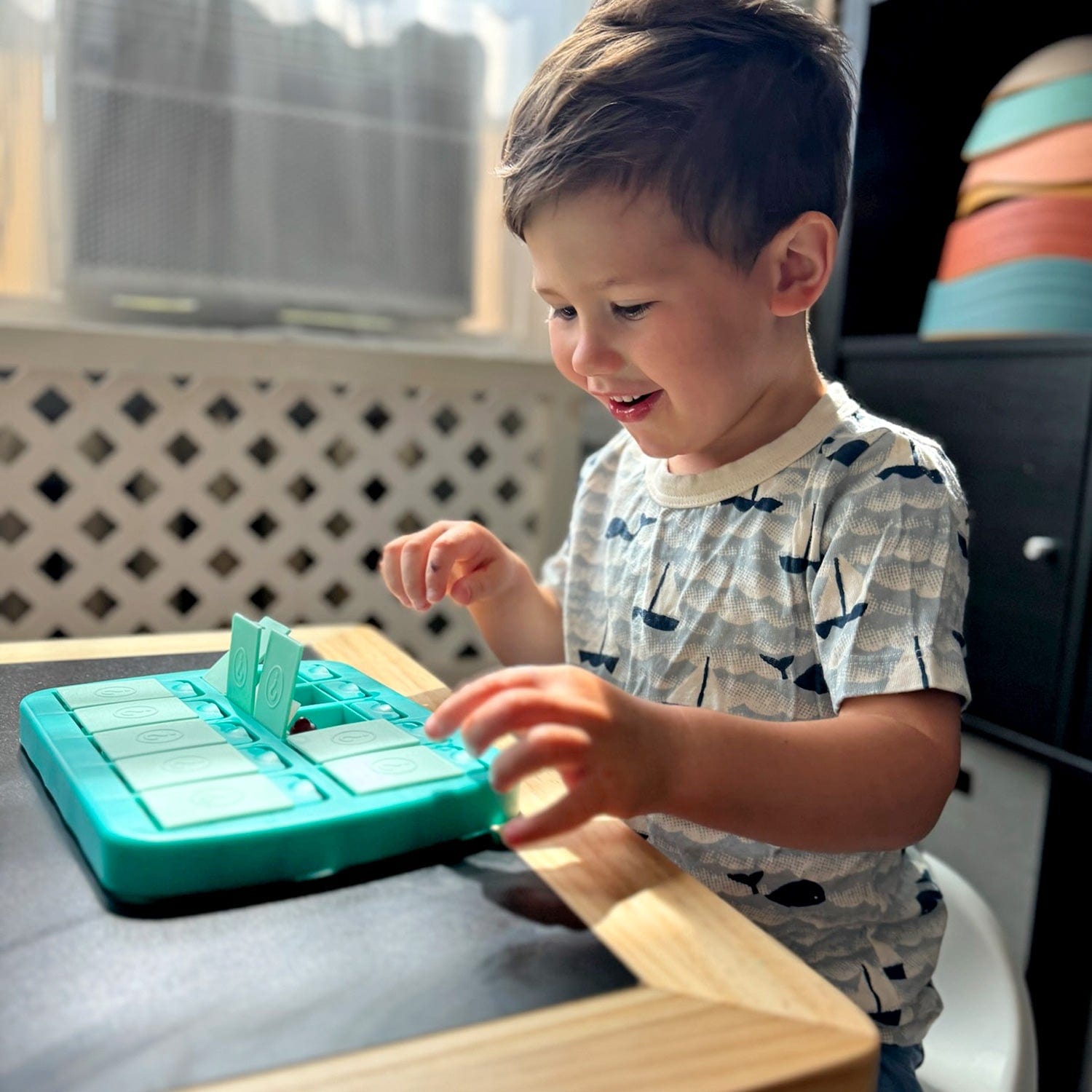 young boy playing mini match up on a black table