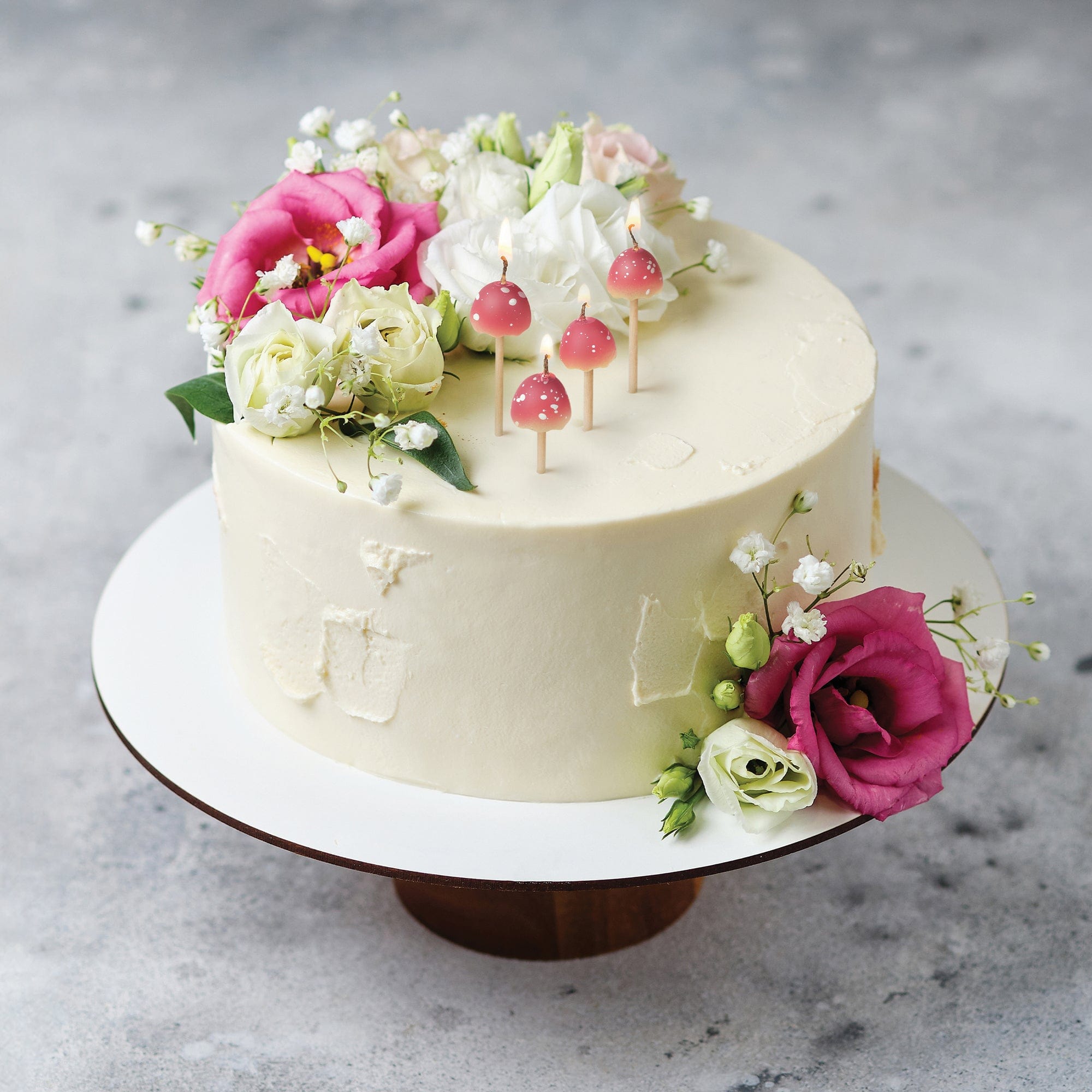 4 mushroom candles in a floral, festive cake